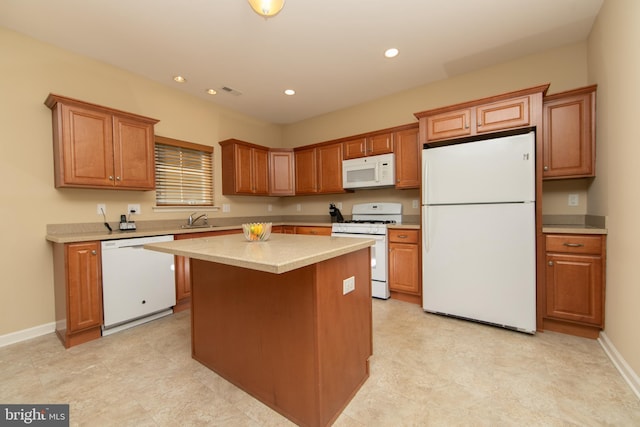 kitchen featuring white appliances, baseboards, a kitchen island, and a sink