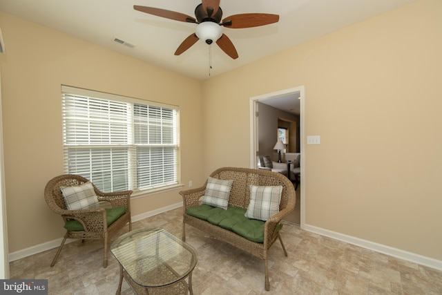 sitting room featuring baseboards, visible vents, and a ceiling fan