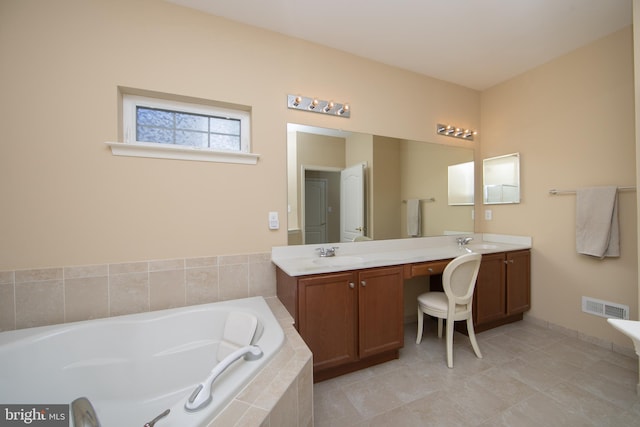 bathroom featuring a garden tub, visible vents, and vanity