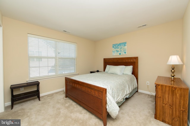 bedroom featuring visible vents, light carpet, and baseboards