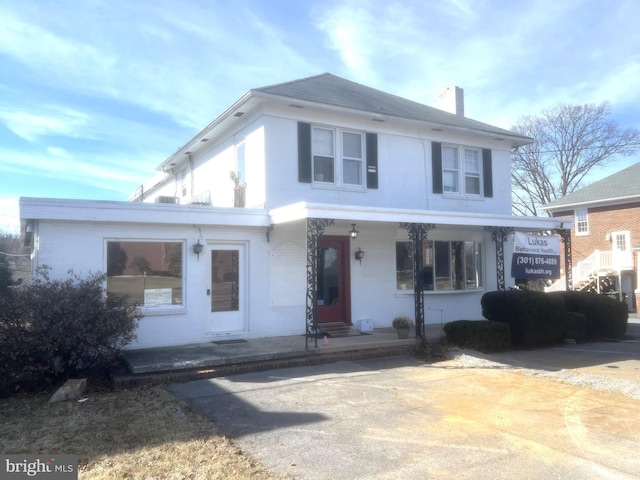 view of front of house with a chimney and brick siding