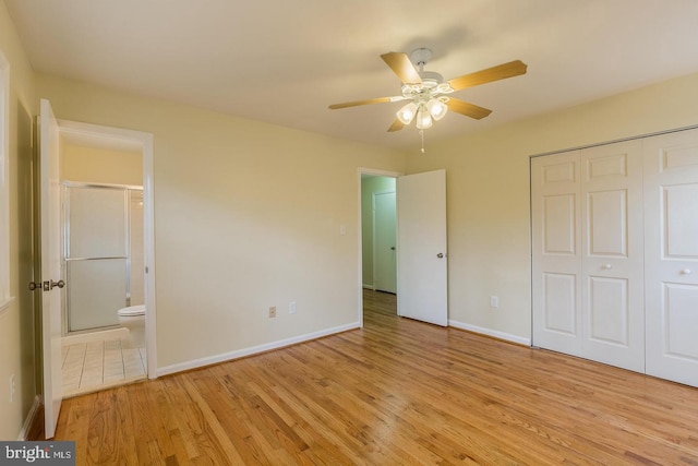 unfurnished bedroom with baseboards, ceiling fan, ensuite bathroom, light wood-style floors, and a closet