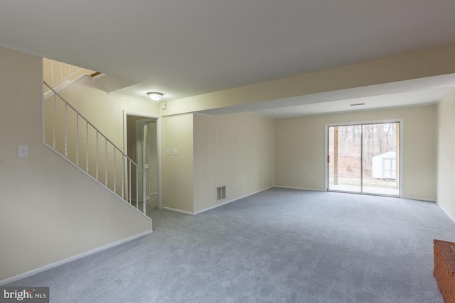 carpeted empty room featuring baseboards, stairs, and visible vents