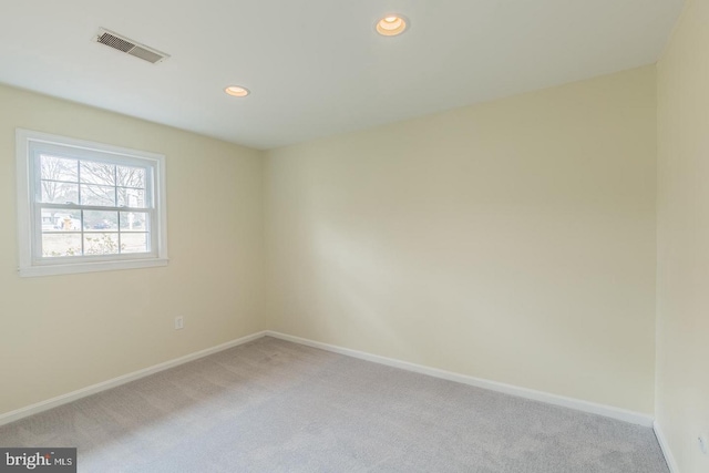 unfurnished room with recessed lighting, carpet, visible vents, and baseboards