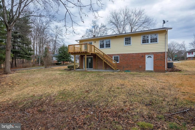 rear view of house featuring a yard, a wooden deck, stairs, and brick siding