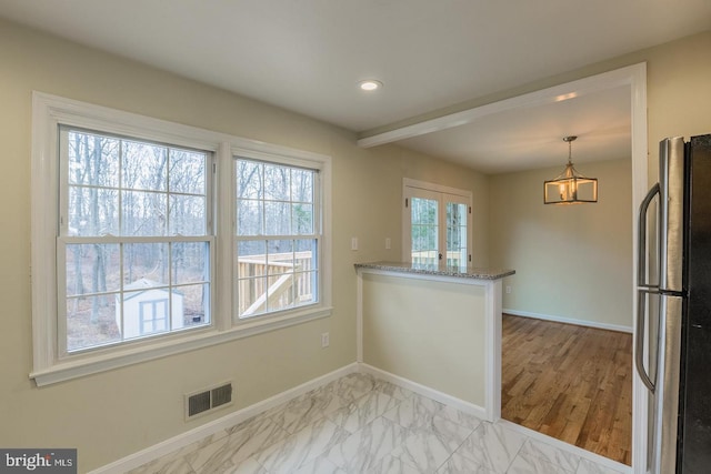 kitchen with freestanding refrigerator, marble finish floor, visible vents, and baseboards