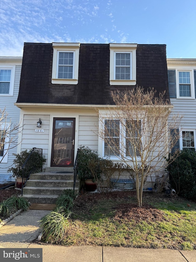 multi unit property featuring a shingled roof and mansard roof