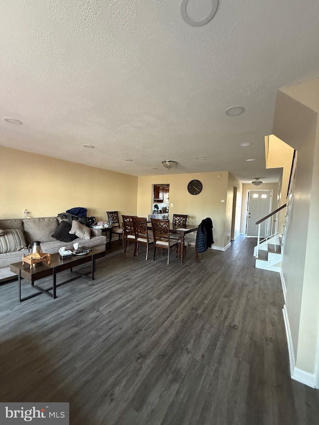 dining room with a textured ceiling, stairs, baseboards, and dark wood-type flooring