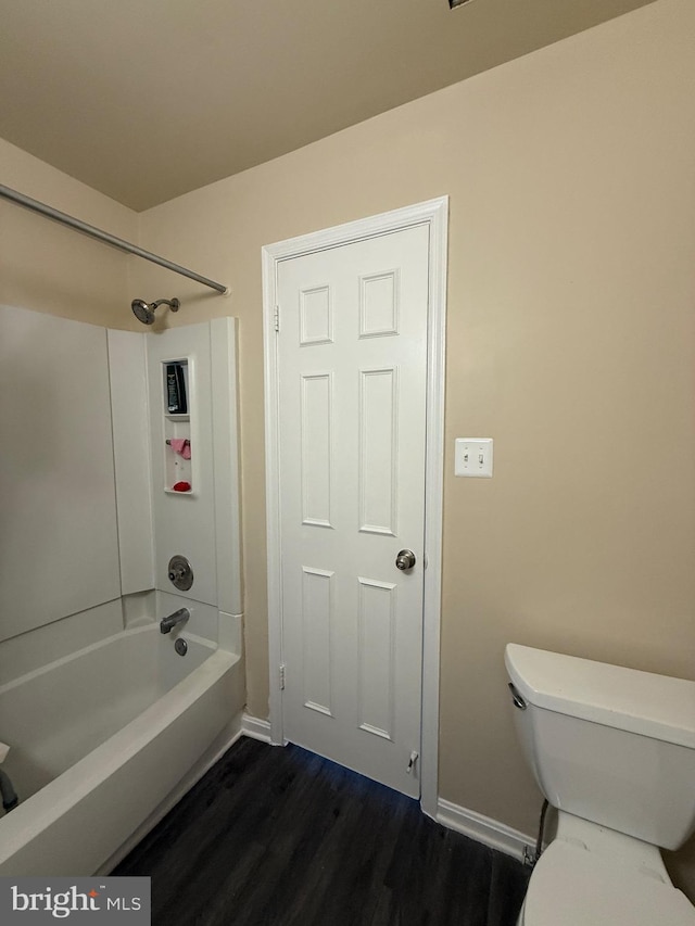 bathroom featuring shower / washtub combination, baseboards, toilet, and wood finished floors