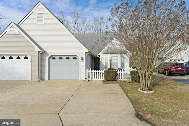 view of front of property featuring roof with shingles, driveway, an attached garage, and fence