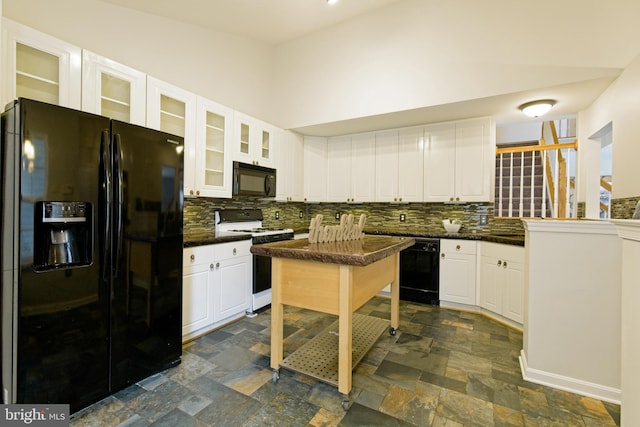 kitchen with stone finish floor, white cabinets, backsplash, and black appliances