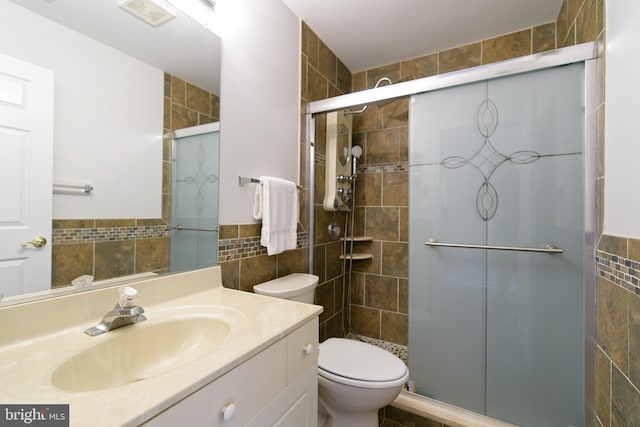 full bathroom with toilet, visible vents, vanity, tile walls, and a shower stall