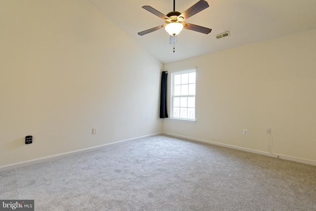 carpeted empty room featuring lofted ceiling, baseboards, visible vents, and a ceiling fan