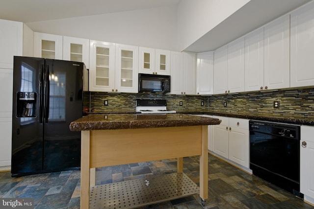 kitchen with black appliances, white cabinetry, stone finish floor, and decorative backsplash