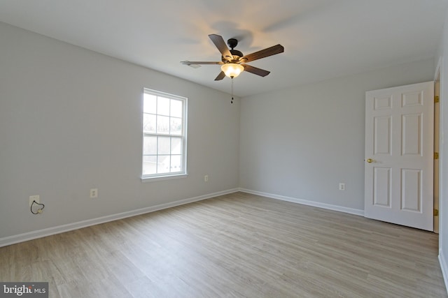 spare room with light wood-style floors, baseboards, and a ceiling fan