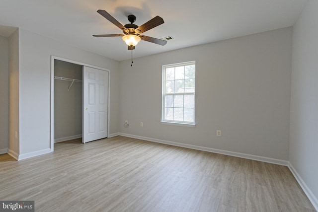 unfurnished bedroom with a closet, light wood-type flooring, a ceiling fan, and baseboards