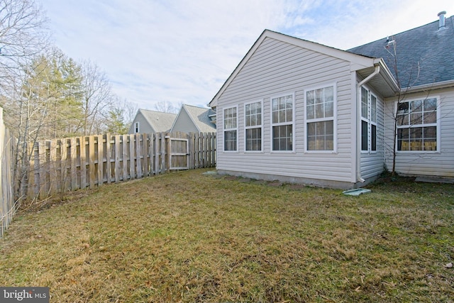 back of house featuring a yard and fence