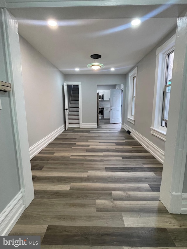 hall featuring stairway, baseboards, dark wood-style flooring, and recessed lighting