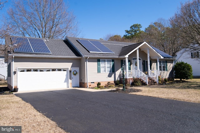 single story home with crawl space, roof mounted solar panels, an attached garage, and driveway