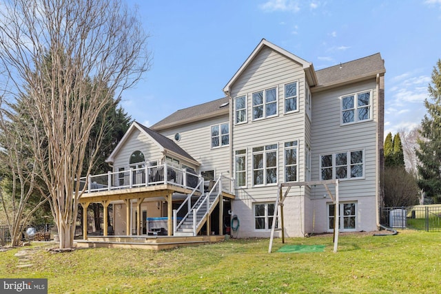 rear view of house featuring stairs, a deck, a lawn, and fence