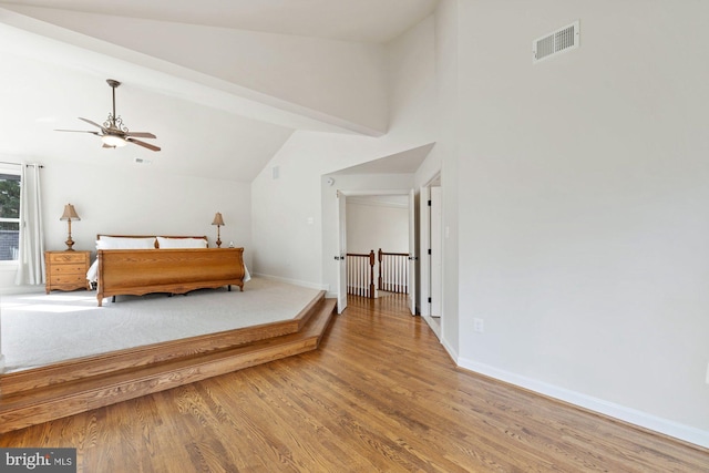 bedroom featuring visible vents, baseboards, wood finished floors, and vaulted ceiling