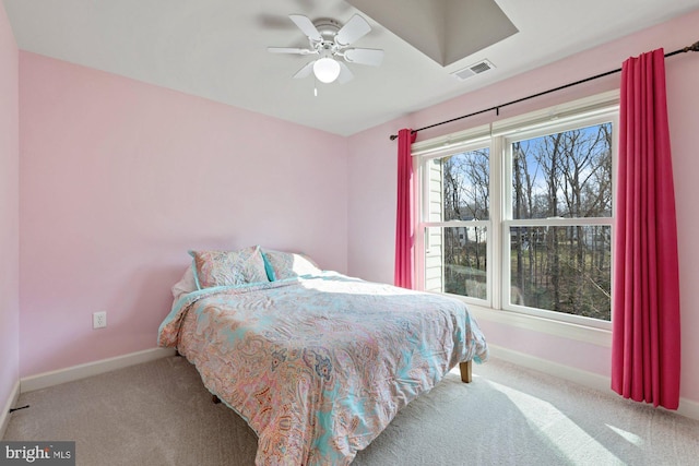 carpeted bedroom with visible vents, baseboards, and ceiling fan