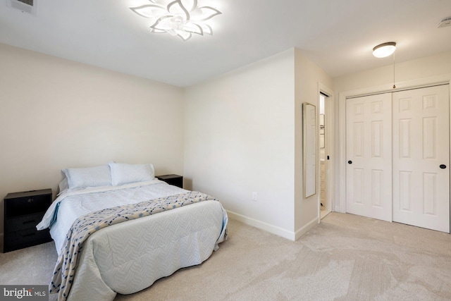 carpeted bedroom with a closet, baseboards, and visible vents