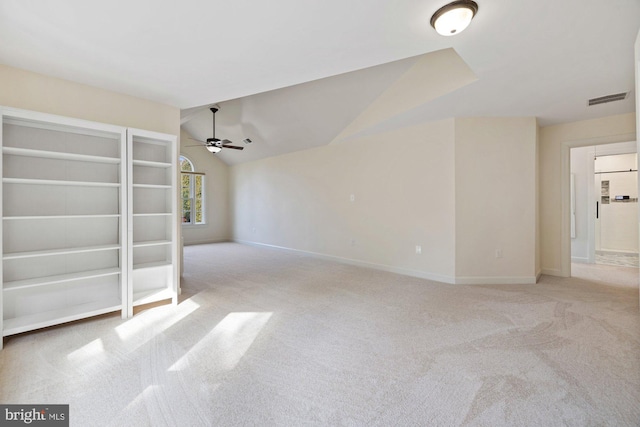 empty room with visible vents, carpet floors, baseboards, ceiling fan, and vaulted ceiling