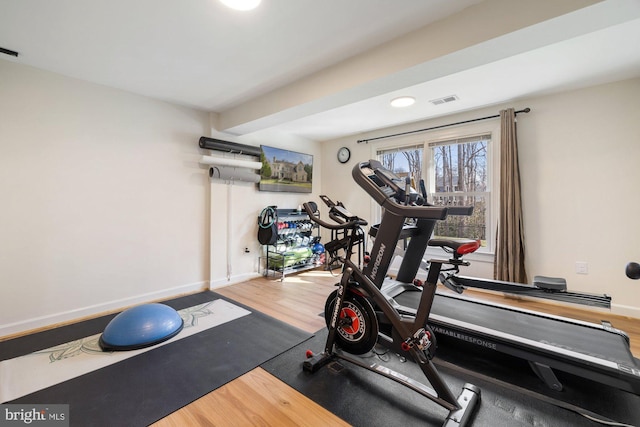 workout area featuring wood finished floors, visible vents, and baseboards