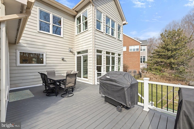 wooden terrace featuring outdoor dining space and a grill