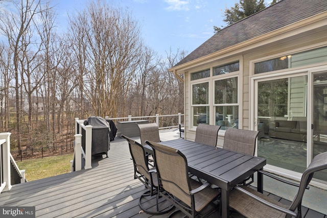 deck featuring an outdoor living space, fence, outdoor dining area, and a sunroom