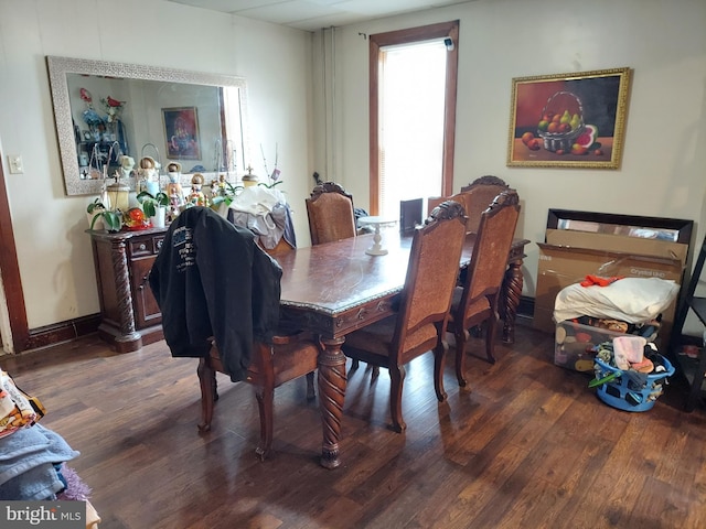 dining space with baseboards and wood finished floors