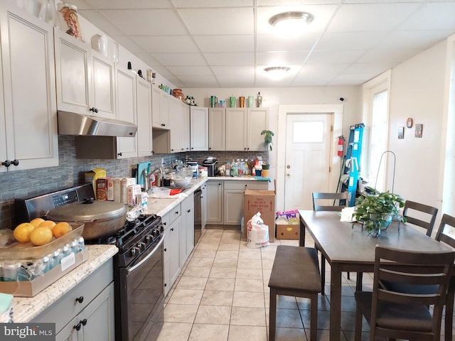 kitchen featuring decorative backsplash, dishwasher, gas range oven, light countertops, and under cabinet range hood