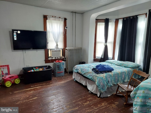 bedroom with radiator and hardwood / wood-style floors