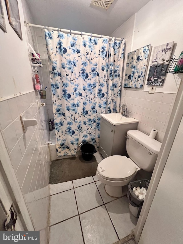 bathroom with toilet, shower / tub combo, visible vents, tile walls, and tile patterned floors