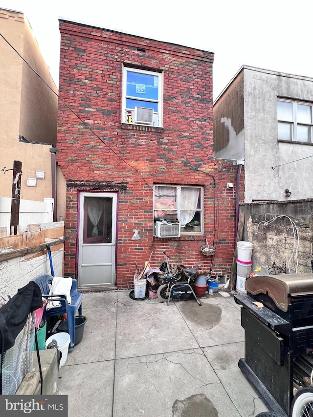 back of property with a patio area and brick siding