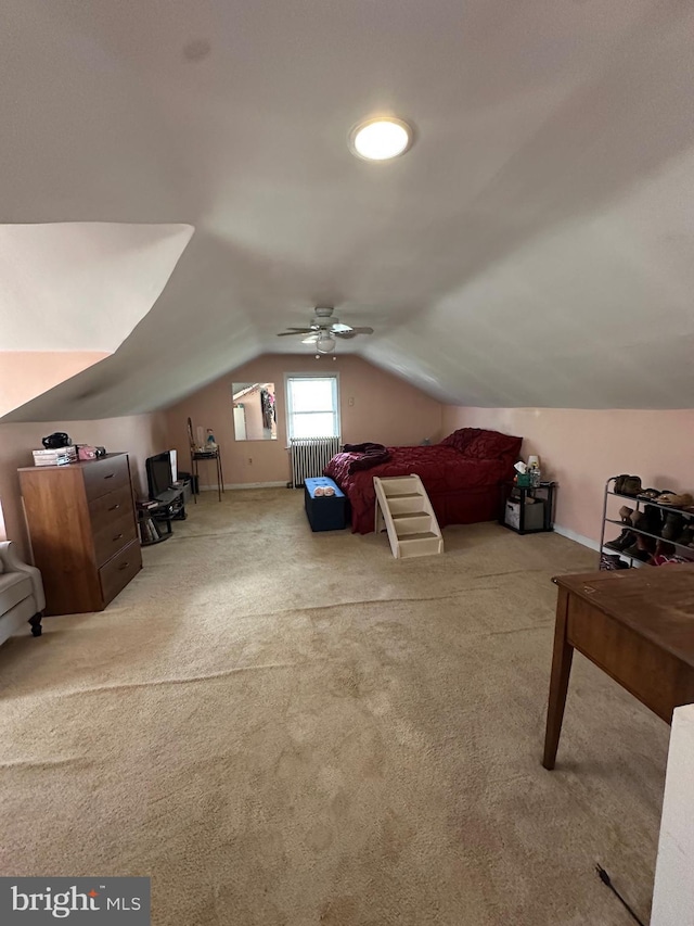 carpeted bedroom with radiator, a ceiling fan, and lofted ceiling