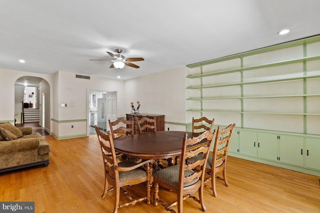 dining room featuring arched walkways, recessed lighting, a ceiling fan, visible vents, and light wood-style floors