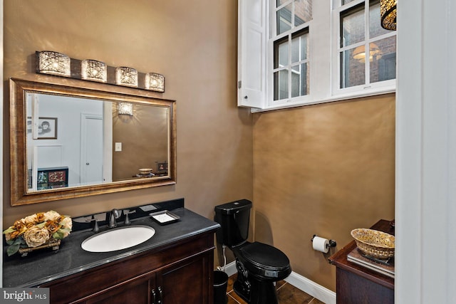 bathroom featuring vanity, toilet, and baseboards