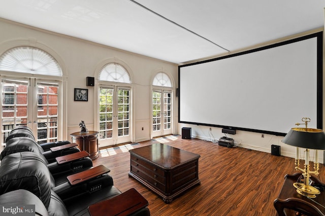 home theater featuring ornamental molding, wood finished floors, and french doors