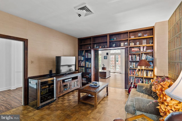 living area featuring parquet floors, wine cooler, and visible vents