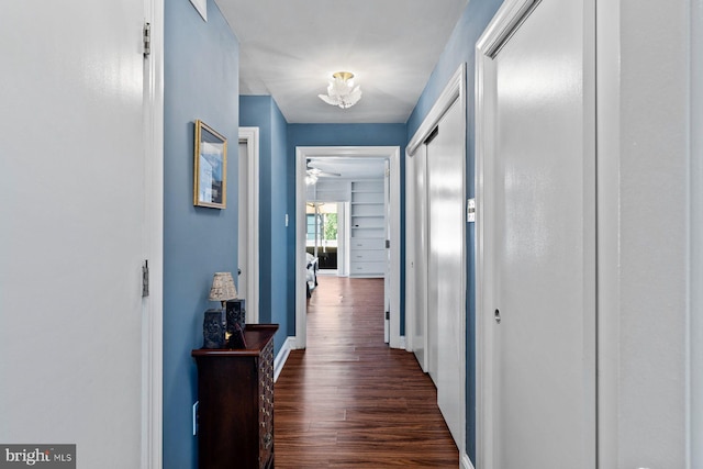 hall with dark wood finished floors and baseboards