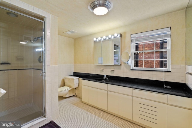 bathroom featuring toilet, a shower stall, tile walls, and tile patterned floors