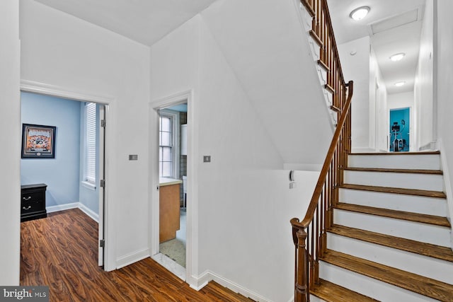 stairs with attic access, baseboards, and wood finished floors