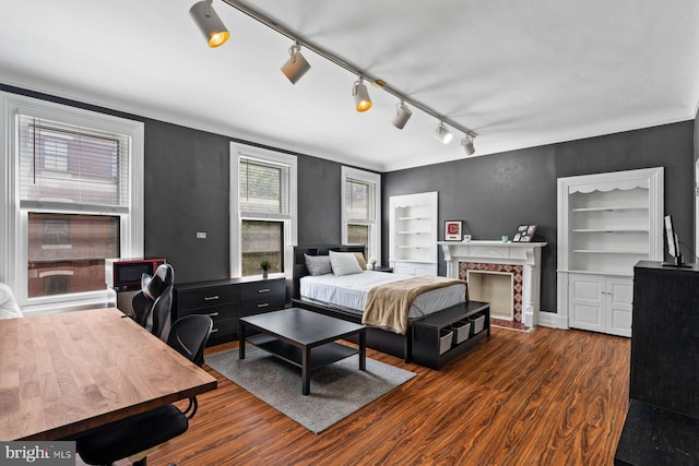 bedroom with a premium fireplace and wood finished floors