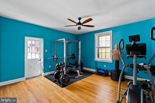 exercise room featuring ceiling fan, wood finished floors, and baseboards