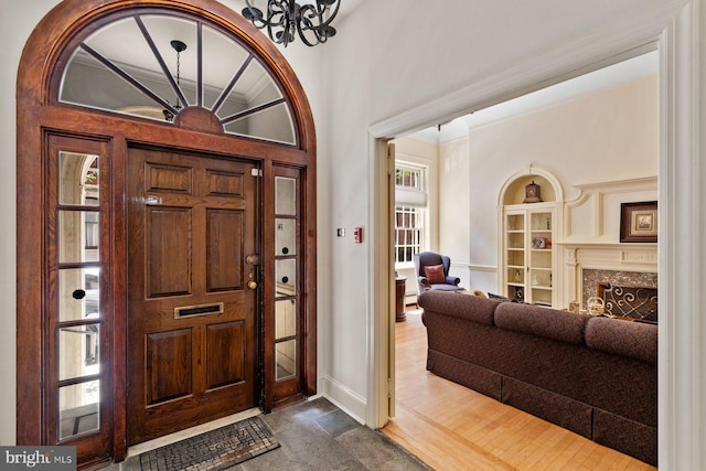 foyer featuring a chandelier and a premium fireplace