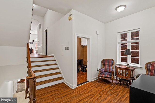 sitting room with visible vents, stairs, baseboards, and wood finished floors