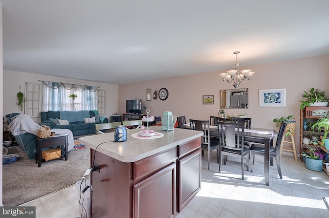 kitchen featuring light countertops, decorative light fixtures, a notable chandelier, open floor plan, and a center island