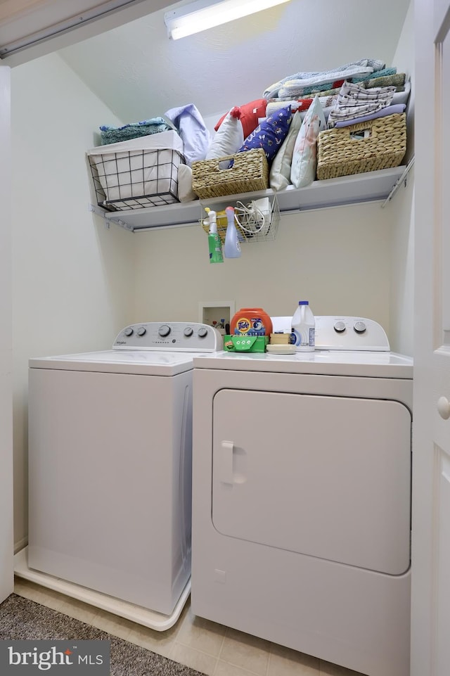 laundry room featuring light tile patterned flooring, laundry area, and independent washer and dryer